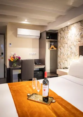 a bottle of wine and two glasses on a table in a hotel room at Hotel Oscar in Amsterdam