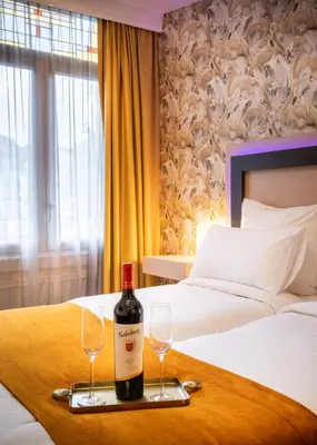 a bottle of wine on a tray with two glasses at Hotel Oscar in Amsterdam