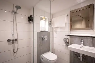 a bathroom with a shower and a toilet and a sink at Hotel Oscar in Amsterdam