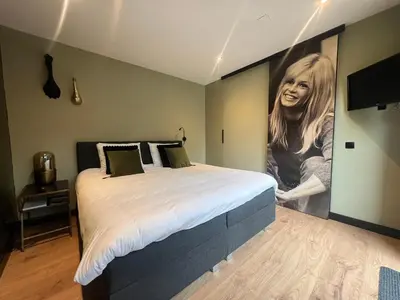 a bedroom with a large poster of a woman at B&B Bardot in Purmerend