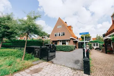 a house with a black gate and a street sign at B&B Bardot in Purmerend