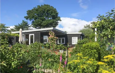 a black house with a garden in front of it at Zeemeermin in Egmond aan Zee