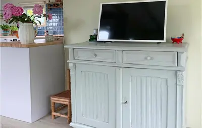 a white dresser with a tv on top of it at Zeemeermin in Egmond aan Zee