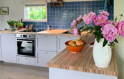 a kitchen with a vase of pink flowers on a counter at Zeemeermin in Egmond aan Zee