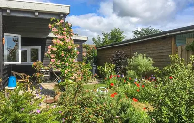 a garden in front of a house with flowers at Zeemeermin in Egmond aan Zee