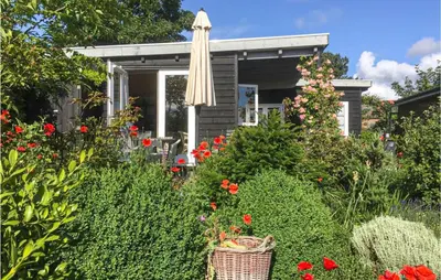 a garden with flowers and a house with an umbrella at Zeemeermin in Egmond aan Zee