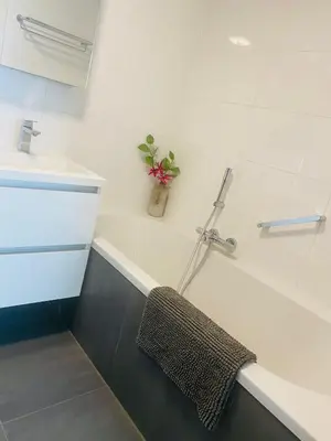 a bathroom with a sink and a bath tub with a towel at Home Inn Zandvoort the First Floor 4 Persons, 2 bedrooms, Free Parking! in Zandvoort
