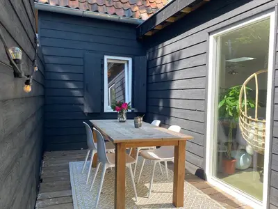 a wooden table and chairs on a patio at Holiday home De Heer van Bergen in Bergen