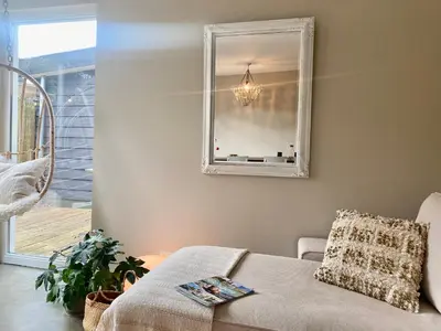 a living room with a couch and a mirror at Holiday home De Heer van Bergen in Bergen
