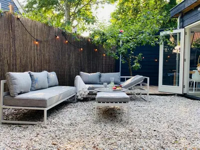 a patio with a couch and a table and a fence at Holiday home De Heer van Bergen in Bergen