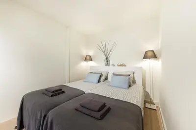 a bedroom with a large bed with two towels on it at Adam's Suite in Amsterdam