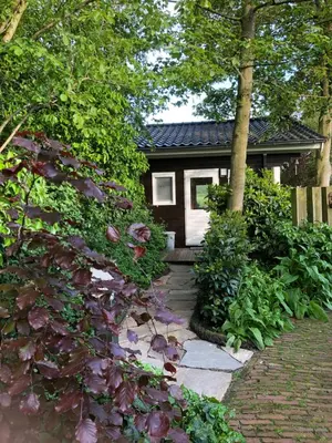 a small house with a brick walkway in front at Klein Langeveld in Noordwijkerhout