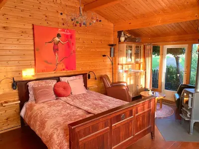 a bedroom with a bed and a painting on the wall at Klein Langeveld in Noordwijkerhout