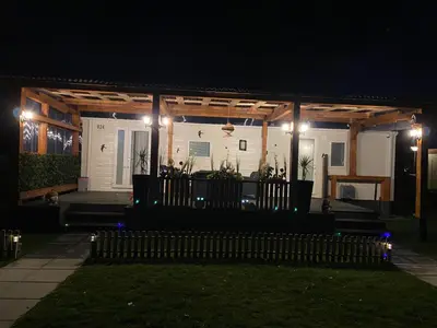 a house with a porch at night with lights at Cheerful and relaxing chalet Viena(Park deHorn824) in Dirkshorn