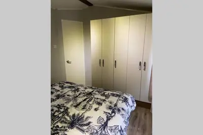 a bedroom with a bed and white cabinets at Cheerful and relaxing chalet Viena(Park deHorn824) in Dirkshorn