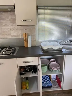 a kitchen with a counter with plates and dishes at Cheerful and relaxing chalet Viena(Park deHorn824) in Dirkshorn