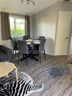 a living room with a dining room table and chairs at Cheerful and relaxing chalet Viena(Park deHorn824) in Dirkshorn