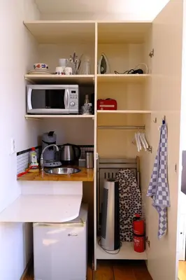 a kitchen with a sink and a microwave on shelves at Eelhouse private studio in Amsterdam