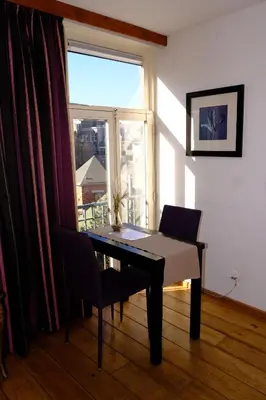 a table and chairs in a room with a window at Eelhouse private studio in Amsterdam
