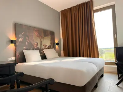 a large bed in a hotel room with a large window at HOTELUX Amsterdam Airport Hotel in Hoofddorp