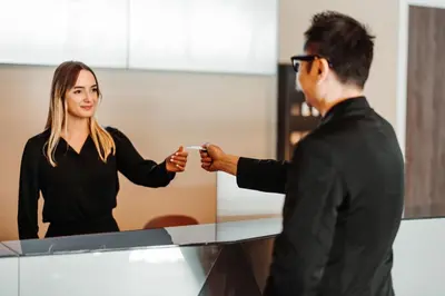 a man and woman shaking hands in front of a mirror at HOTELUX Amsterdam Airport Hotel in Hoofddorp