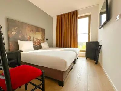 a hotel room with two beds and a window at HOTELUX Amsterdam Airport Hotel in Hoofddorp