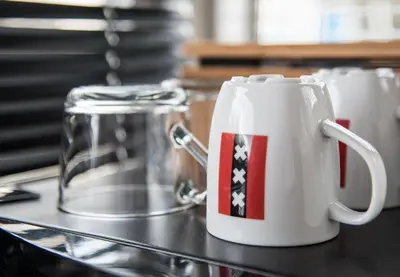 a white coffee mug with an american flag on it at HouseBoat next to AMSTEL in Amsterdam