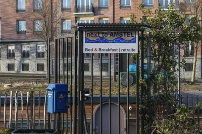 a gate with a sign in front of a building at HouseBoat next to AMSTEL in Amsterdam