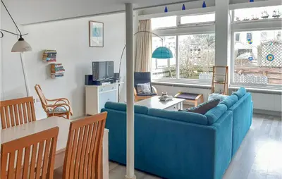 a living room with a blue couch and a table at Elfrank in Bergen aan Zee