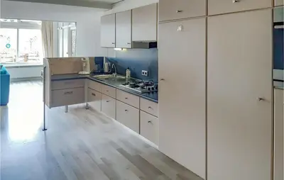 a kitchen with white cabinets and a sink at Elfrank in Bergen aan Zee