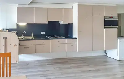 a kitchen with white cabinets and a sink at Elfrank in Bergen aan Zee