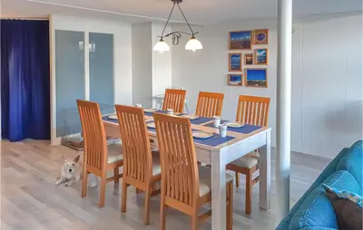 a dining room table with chairs and a dog sitting around it at Elfrank in Bergen aan Zee