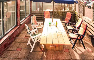 a wooden table and chairs on a patio at Elfrank in Bergen aan Zee