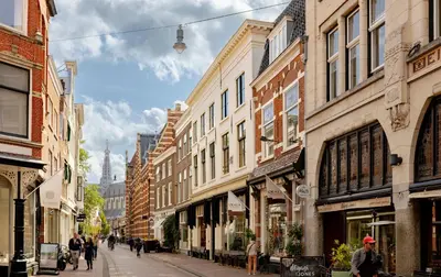 a street with buildings and people walking down a street at MAF Haarlem Boutique Hotel in Haarlem