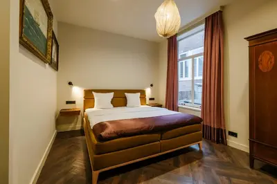 a bedroom with a large bed and a window at MAF Haarlem Boutique Hotel in Haarlem