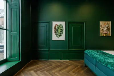 a bedroom with green walls and a bed with a blue bench at MAF Haarlem Boutique Hotel in Haarlem
