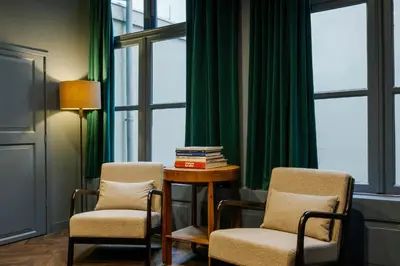 two chairs and a table in a room with green curtains at MAF Haarlem Boutique Hotel in Haarlem
