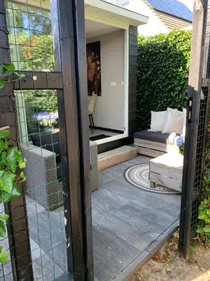 a door leading to a patio with a couch at Petite Maison Bennebroek in Bennebroek