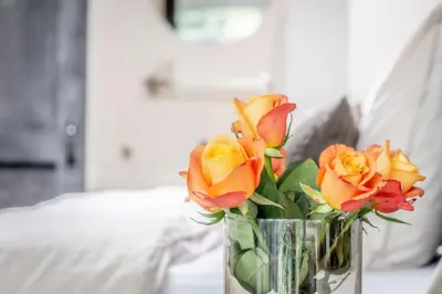a vase filled with yellow and red flowers on a table at Petite Maison Bennebroek in Bennebroek