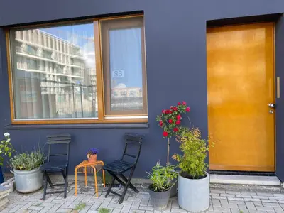 a blue building with two chairs and a table with plants at Bed & Beach Amsterdam in Amsterdam