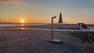 a beach with an umbrella and a table and an umbrella at Bed & Beach Amsterdam in Amsterdam