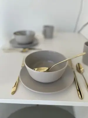 a bowl on a plate with a spoon on a table at Bed & Beach Amsterdam in Amsterdam