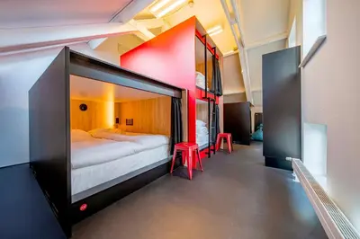 a large bed in a room with two bunk beds at City Trip Hostels Amsterdam-Purmerend in Purmerend