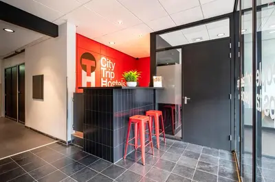 a bar in a building with red walls and stools at City Trip Hostels Amsterdam-Purmerend in Purmerend