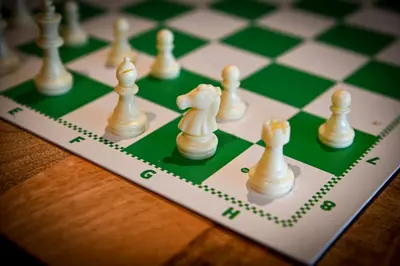a chess board with white chess pieces on it at City Trip Hostels Amsterdam-Purmerend in Purmerend