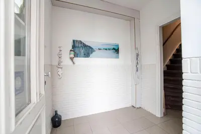 a hallway with a white door and a picture on the wall at Seawave Studio in Zandvoort