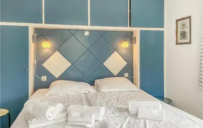 a bedroom with a large white bed with blue walls at Blaauburgh in Bergen aan Zee
