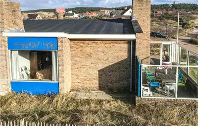 a brick house with a blue door and a balcony at Blaauburgh in Bergen aan Zee
