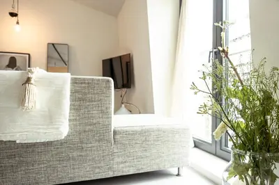 a living room with a couch and a window at Appartementen Zer en Loft in centrum Bergen in Bergen