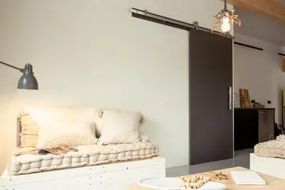 a living room with a couch in front of a wall at Appartementen Zer en Loft in centrum Bergen in Bergen